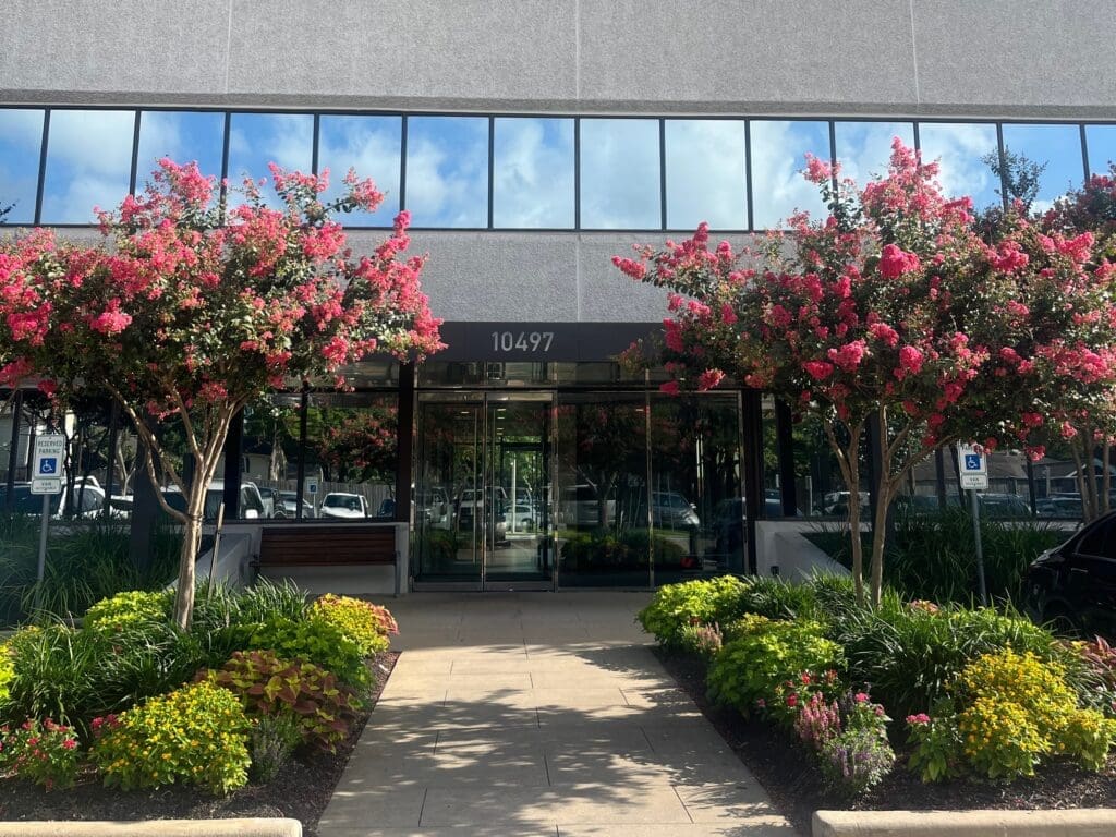 An exterior photo of the main entrance into the building where Airrosti Memorial City is located.