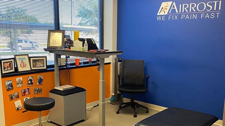 photo of another view of the inside of the treatment room at Airrosti Pearland. Includes the provider's desk.