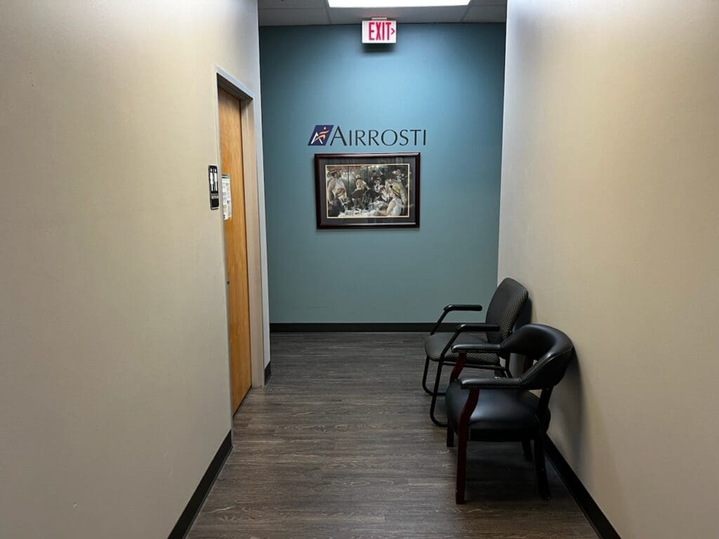 Photo of interior hallway at Airrosti Rowlett. Airrosti logo printed on wall.
