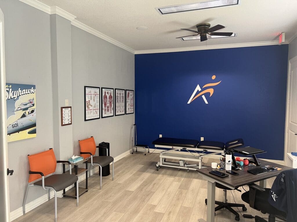a view of the treatment room at Airrosti South Fort Worth. Includes posters on the wall, chairs, and the treatment table.