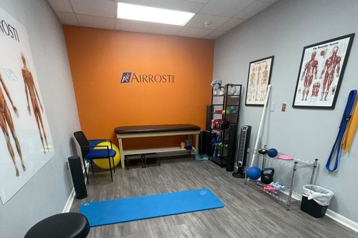 Airrosti University_Rehab_Room with treatment table and airrosti logo