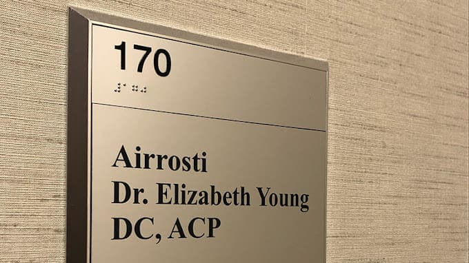a close up photo of the nameplate located outside the interior entrance of Airrosti Willowbrook