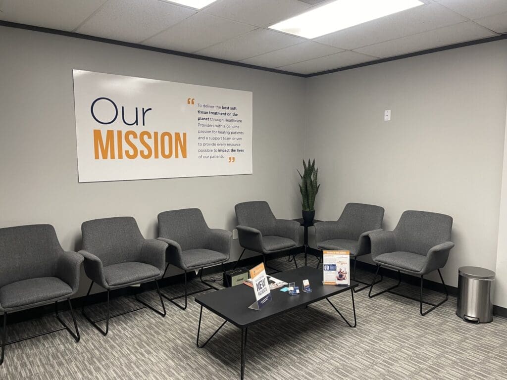 The interior lobby at Airrosti the Woodlands. Our Mission poster is featured on the back wall.