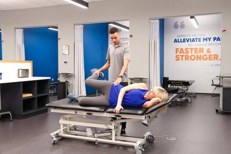 Airrosti Provider and patient in 168飞艇/幸运飞行艇168开奖官方开奖结果查询 treatment room, performing treatment on hip