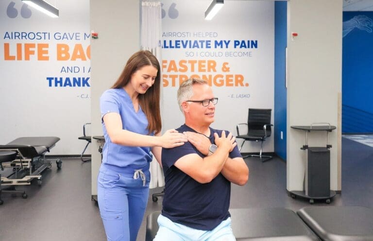 Airrosti Provider with patient performing treatment on his shoulder
