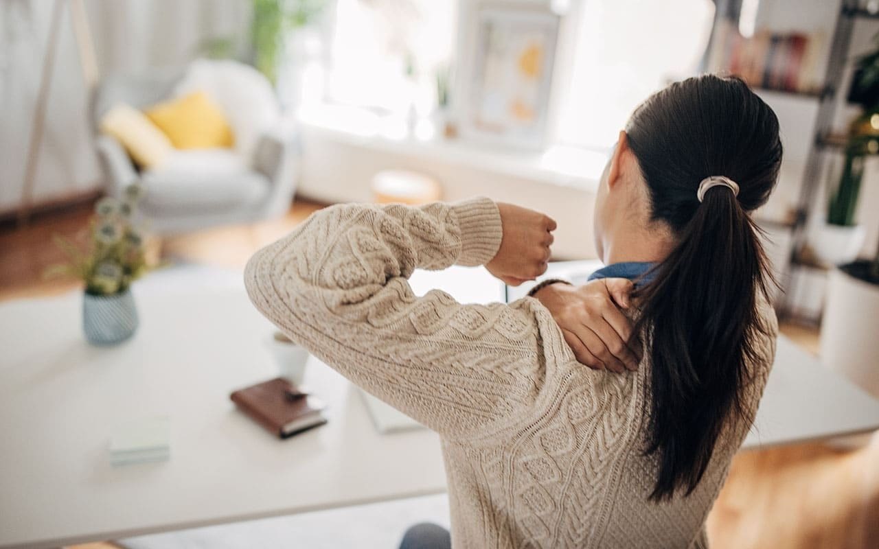 Woman Grabbing Her Upper Back in Pain